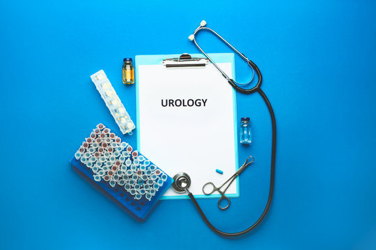 Clipboard with text UROLOGY, stethoscope, medicines and test tubes on color background
