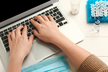 Female doctor working on laptop at table