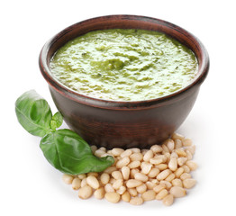 Bowl of tasty pesto sauce on white background