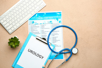 Paper sheet with text UROLOGY, stethoscope, laboratory test form and computer keyboard on color...