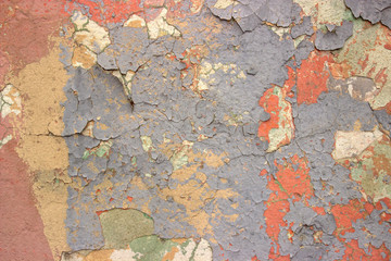  An old wall with many layers of paint of different colors.