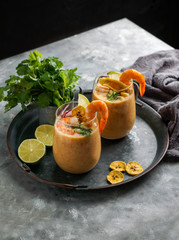 leche de tigre, Peruvian,  Ecuador, Latin American food, raw fish cocktail ceviche with lime, aji limon and cilantro. Traditional peruvian food with srimps and banana chips