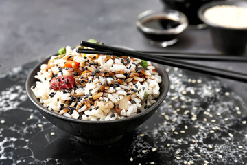 Boiled rice with vegetables in bowl on table