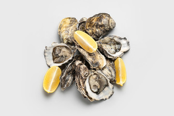 Tasty oysters with lemon on white background