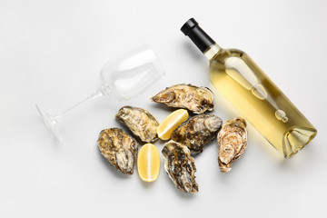 Tasty oysters with wine on white background