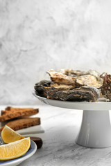 Stand with tasty oysters on table