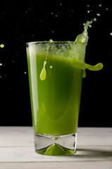 Healthy green juice or smoothie on the dark background