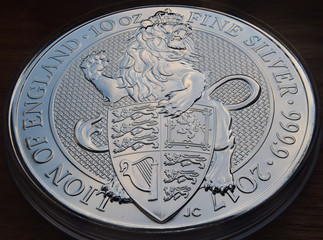 A silver lion behind a shield, queens beast coin macro