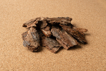 Fototapeta na wymiar Heap of Pine Tree Bark Chip on Brown Cork Board Background
