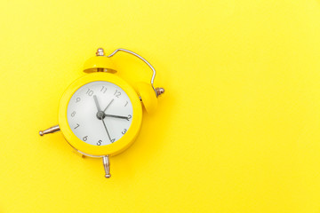 Ringing twin bell vintage classic alarm clock Isolated on yellow colourful trendy modern background. Rest hours time of life good morning night wake up awake concept. Flat lay top view copy space.