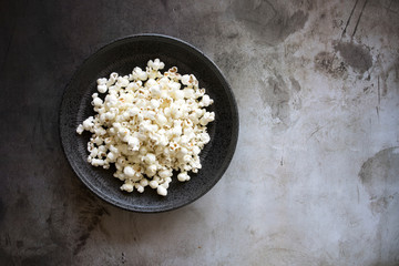 Popcorn in a Bowl on a Concrete Background with room for Copy