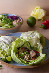 Stuffed iceberg lettuce leaves with turkey and vegetables on blue plate. Healthy diet food
