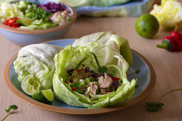 Stuffed iceberg lettuce leaves with turkey and vegetables on blue plate. Healthy diet food