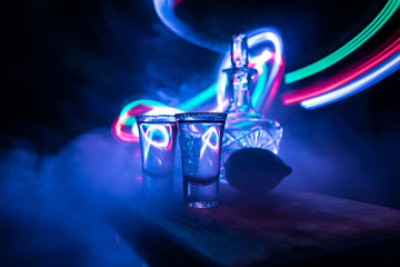 Club drink concept. Tasty alcohol drink cocktail tequila with lime and salt on vibrant dark...