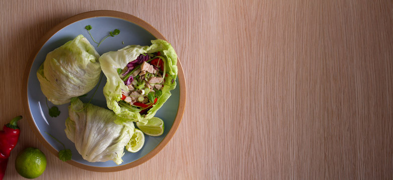 Stuffed iceberg lettuce leaves with turkey and vegetables on blue plate. Healthy diet food. Overhead image, room for text
