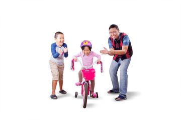 Father and son cheering for the girl riding a bike