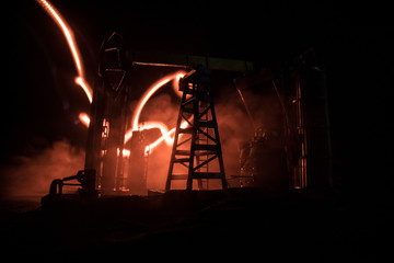 Artwork decoration. Oil pump and oil rig energy industrial machines for petroleum at night with fog...