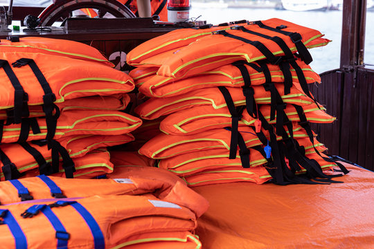 Piles of orange life vest on a boat