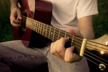 Fototapeta na wymiar Man playing a red acoustic guitar