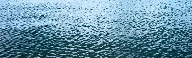 Panoramic banner background, abstract rippled water surface in perspective.