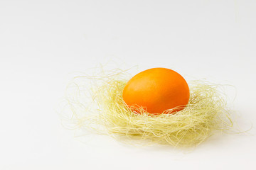 Easter orange egg on sisal/straw.