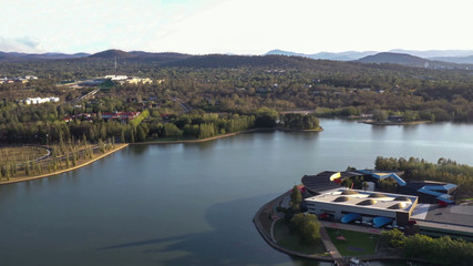 Fototapeta premium Aerial view of Canberra City, Australia, looking over Lake Burley Griffin and Acton Peninsula toward Australian Parliament House on a sunny afternoon 
