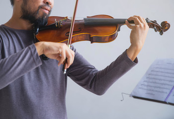 Symphony orchestra on white background, hands playing violin. Male violinist playing classical...