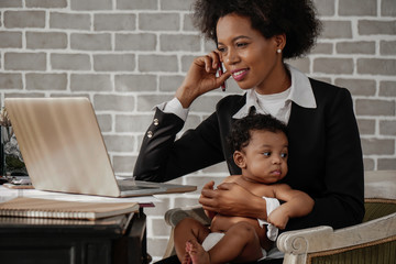african american business woman with baby working at home