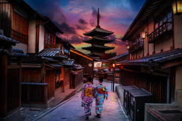 Two geishas wearing traditional japanese kimono among at Yasaka Pagoda and Sannen Zaka Street in...