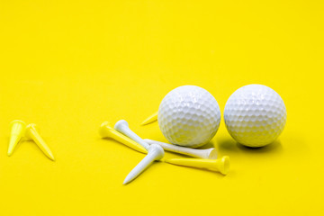 Golf ball and tee are on yellow background