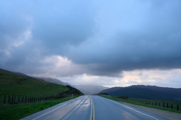 Road Heads into Big Sur Hills Under Rainy Clouds