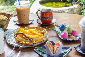 French fries, iced coffee, espresso and hot coffee , Mochi, Japanese sweets on a wooden table in a restaurant Food background