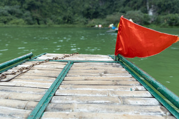 selective focus of bamboo boat trip with beautiful blurred mountain and green river.