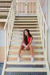 Street fashion summer portrait of a women on stairs outdoors.