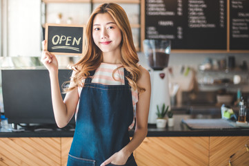 Fototapeta na wymiar Portrait young Asian woman barista feeling happy smiling at urban cafe. Small business owner Korean girl in apron relax toothy smile