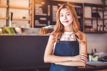 Portrait young Asian woman barista feeling happy smiling at urban cafe. Small business owner Korean girl in apron relax toothy smile