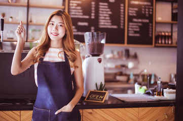Portrait young Asian woman barista feeling happy smiling at urban cafe. Small business owner Korean girl in apron relax toothy smile