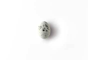 White Easter egg with splatter design on white background.