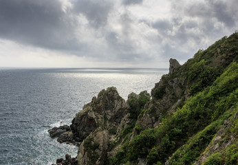 Magnificent seascape overlooking the dark cloudy sky, the steel sea and the high, dangerous rocks.