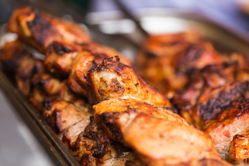 Delicious bbq kebab grilling on open grill, outdoor kitchen. Food festival in city. Tasty food roasting on skewers, food-court. Summer picnic