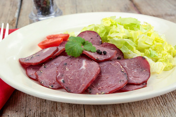 tranches de saucisson au poivre dans une assiette