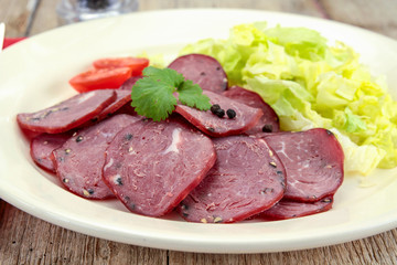tranches de saucisson au poivre dans une assiette