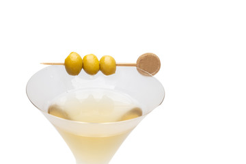 Martini cocktail with green olives on marble board. Close up.Classic glass of dry Martini with three olives isolate.