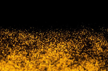 Gold abstract glitter bokeh on black background