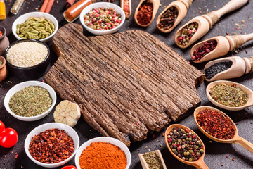 Spices and herbs over black stone background. Top view with free space for menu or recipes
