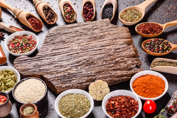 Spices and herbs over black stone background. Top view with free space for menu or recipes