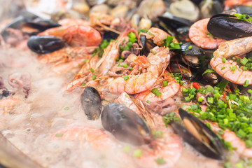 Street food and meal - Spanish paella close-up with shrimp and clams