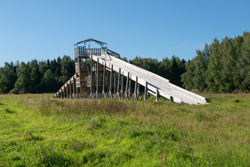 Fototapeta na wymiar Wooden slide for winter fun on a summer day