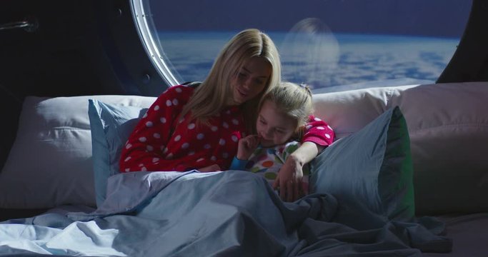 Mother and daughter using smartphone in a spaceship
