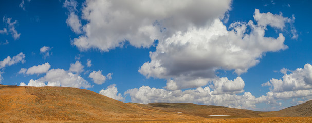 Desert hills and picturesque blue sky with white clouds, panoramic view